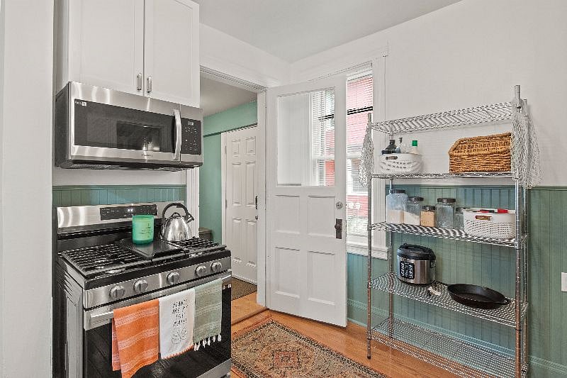Kitchen view into laundry room door featuring storage