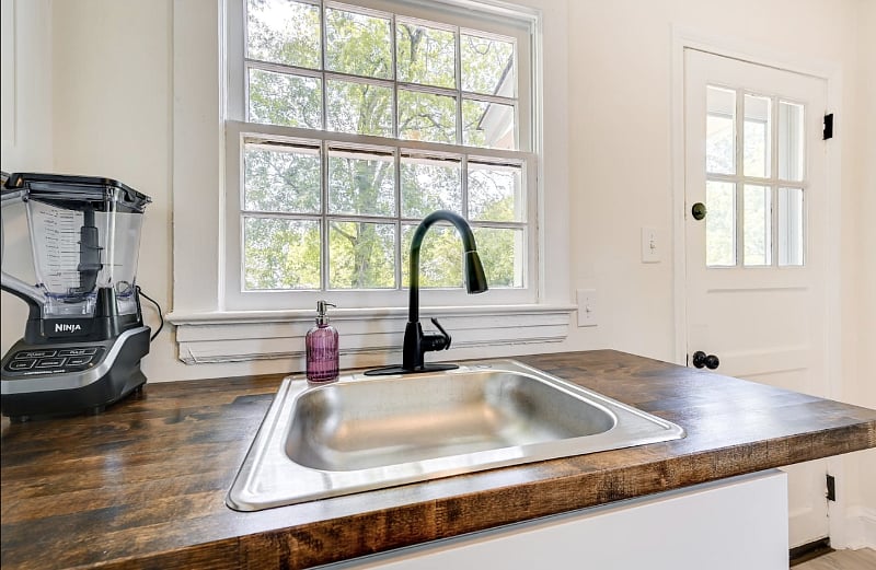 With white cabinets and a beautiful dark wood worktop providing an aesthetic contrast