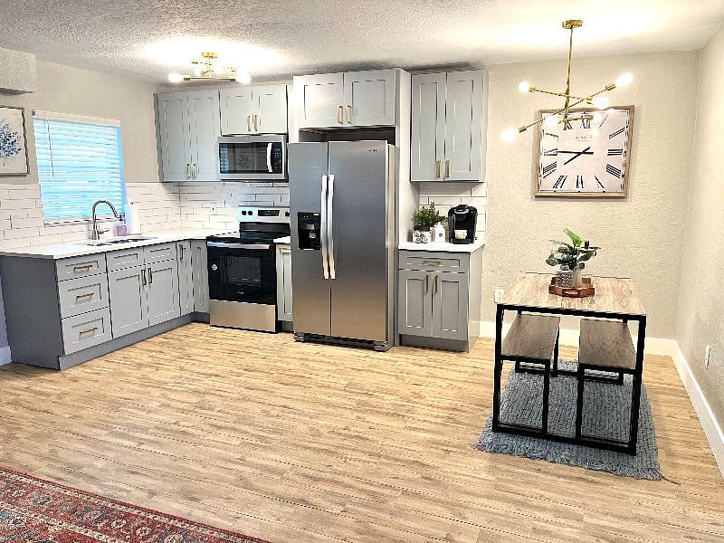 An open floor plan featuring a newly renovated kitchen with brand new stainless steel appliances.