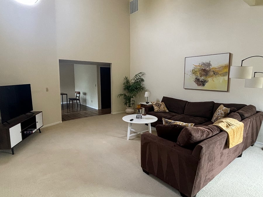 View of living room showing large-screen TV and dining room.