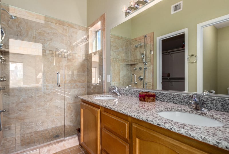 Private bedroom off primary bedroom.  Upgraded shower with multiple shower heads, two sinks and toilet with a door.