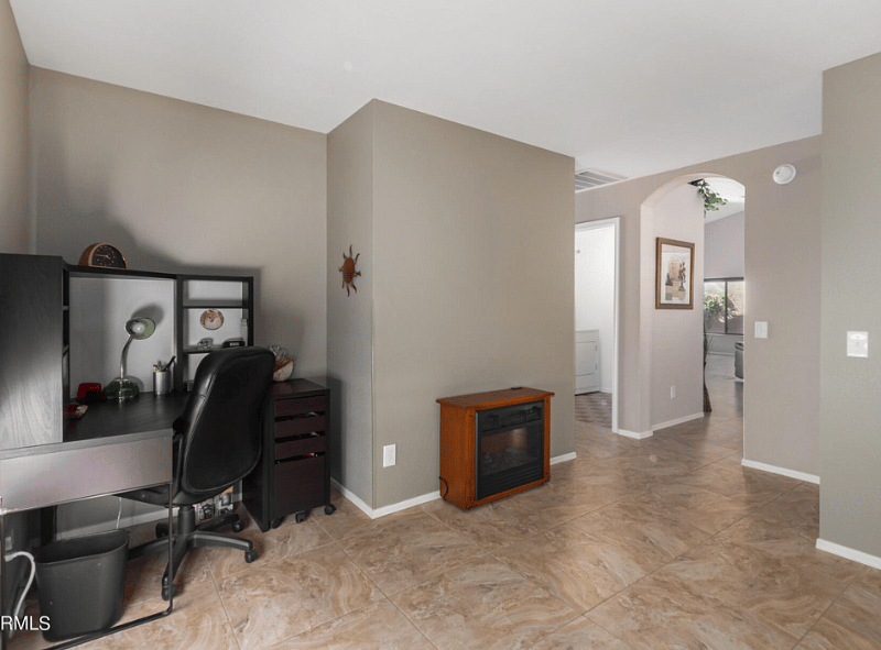 Den with desk and office chair.  Also includes shelving and a murphy bed.