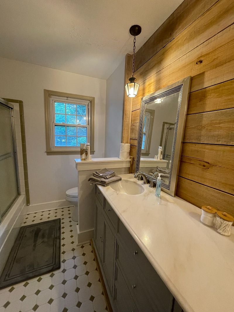 Shared bathroom; new toilets, vanity, mirrors, paint, and decorative cypress wood accent wall.