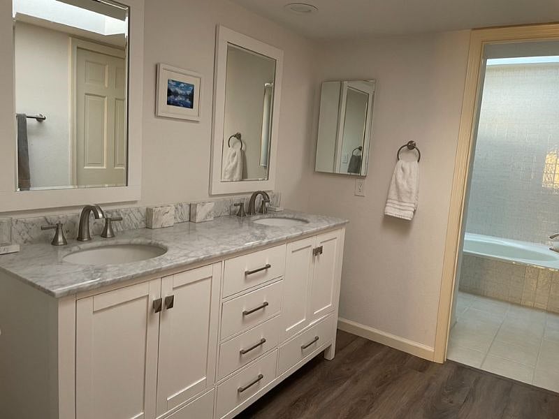 Primary Vanity leading towards bathtub, toilet, and walk in shower