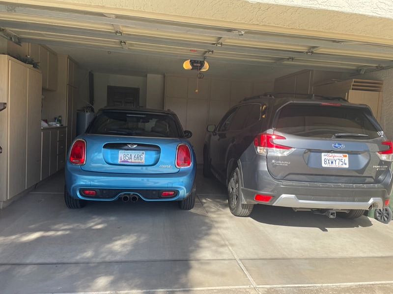 Two car garage connected to Townhome with storage cabinets