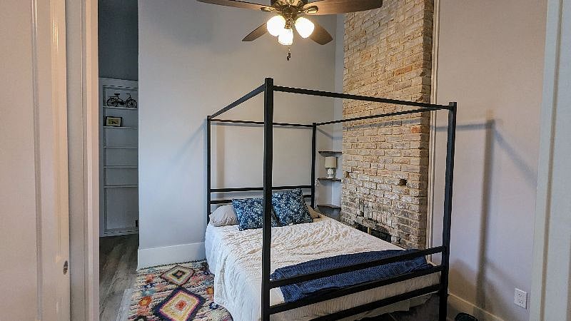 Bedroom includes queen bed, full length mirror, closet with hangers, linens, and dresser.