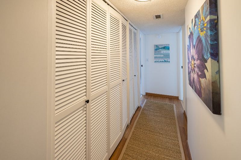 Full size washing machine and dryer in hallway near bedrooms.