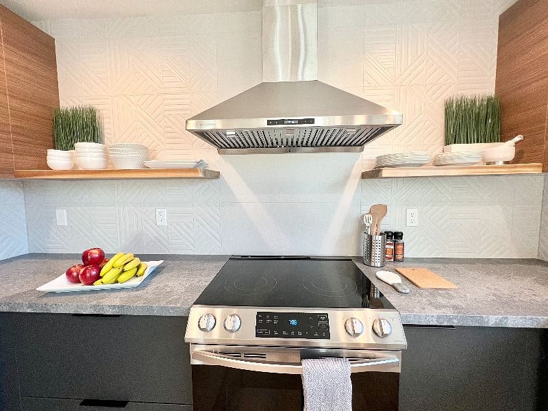 Counter-to-ceiling backsplash tiles, electric stove, oven, fully stocked kitchen, cookware, dinnerware, utensils, etc. 