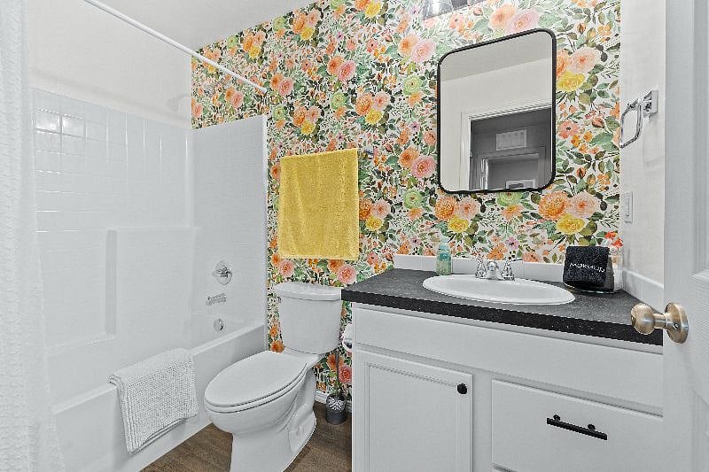 Bright and airey guest bathroom with full tub and shower combo. Starter amenities provided as well as towels and rugs for your use
