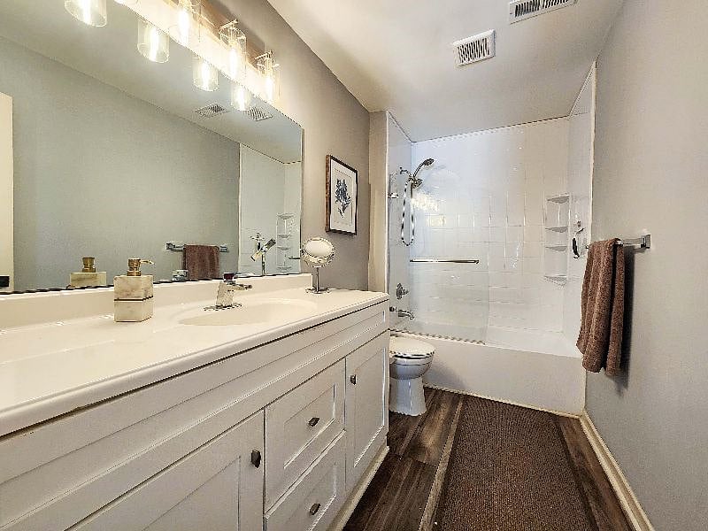 Master bathroom tub/shower with glass shower door and handheld shower head.