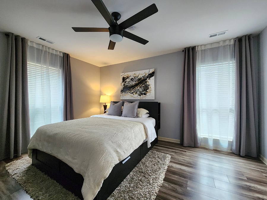 Ample master bedroom with queen-size mattress and ceiling fan