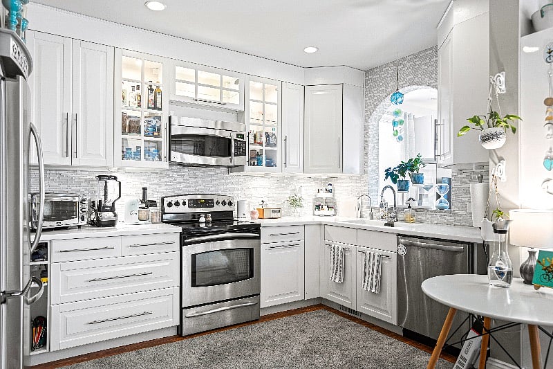 Modern kitchen with sunny windows and beautiful greenery.
