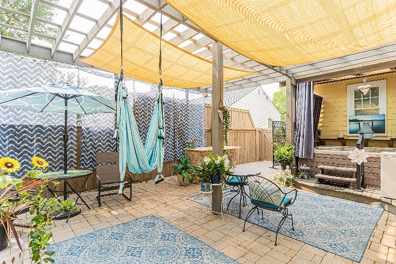 The back patio with a shaded pergola, yoga swing, cold plunge, outdoor hot and cold shower and salt water hot tub.