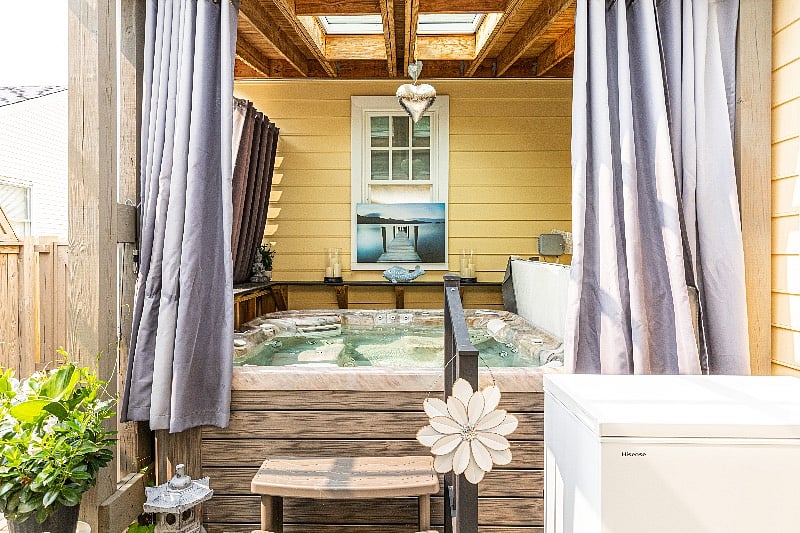 The backyard oasis with a salt water hot tub, cold plunge, hot and cold water shower and privacy curtains.