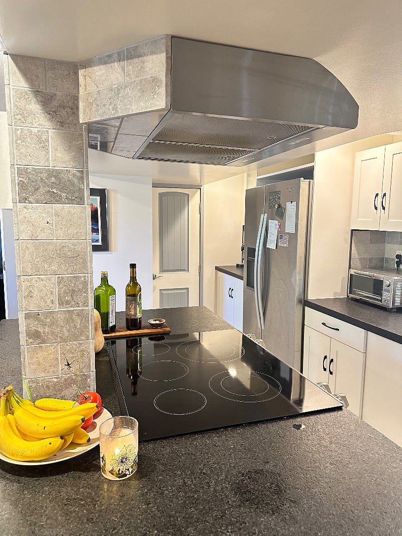 Kitchen over island stove, full refrigerator, lots of counters.