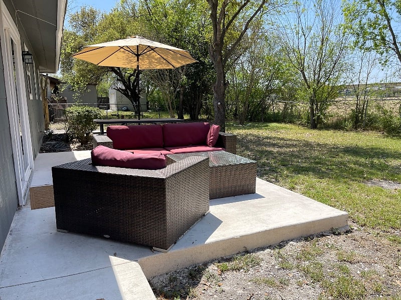 Spacious Back Yard with Patio Furniture and Fire