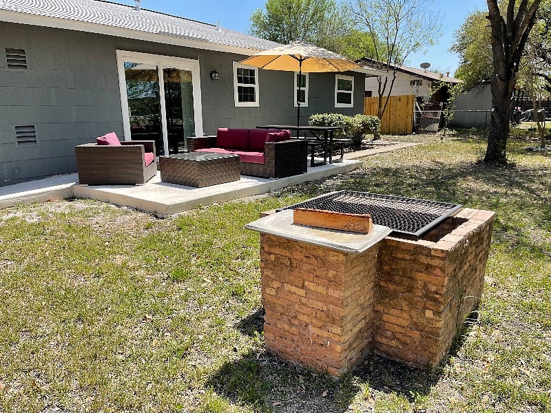Spacious Back Yard with Patio Furniture and Fire