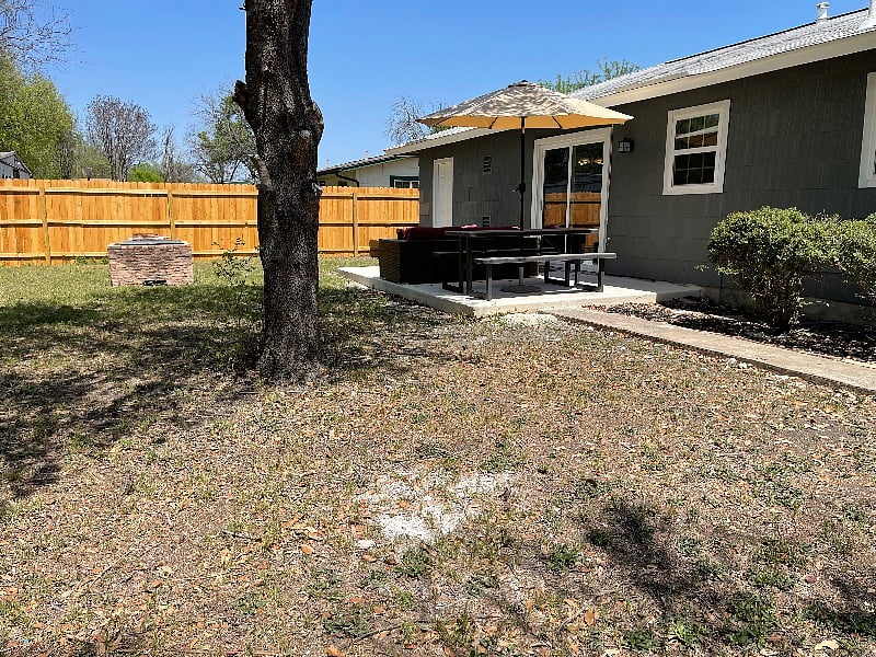 Spacious Back Yard with Patio Furniture and Fire