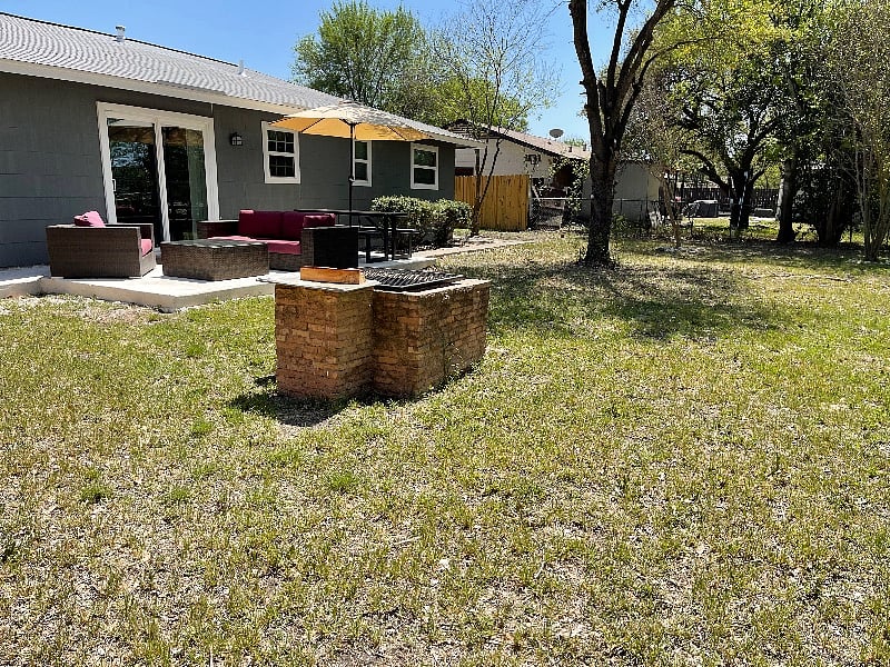 Spacious Back Yard with Patio Furniture and Fire