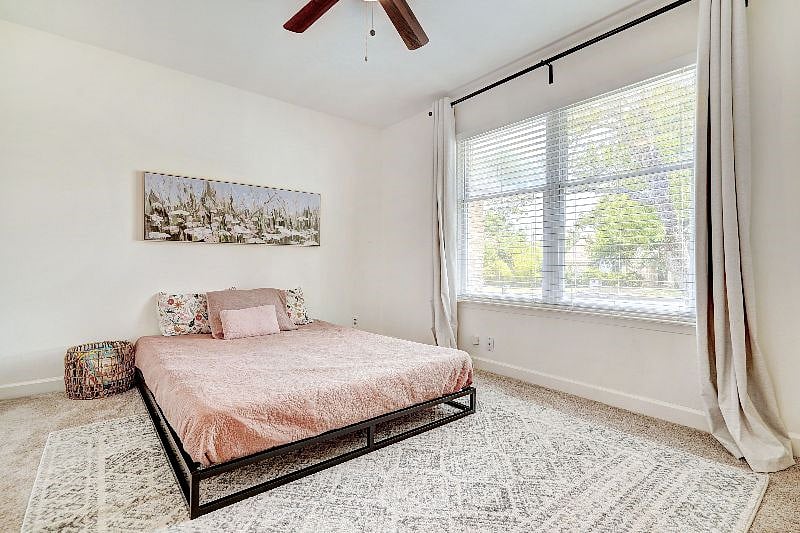 Large guest bedroom with queen bed and a lot of natural light