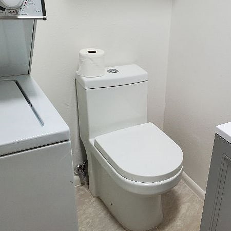 Small vanity plus a mirrored medicine cabinet above sink. Pocket door entry to bathroom. Cabinets above, w/linens & hair dryer. W/D stack to left. 