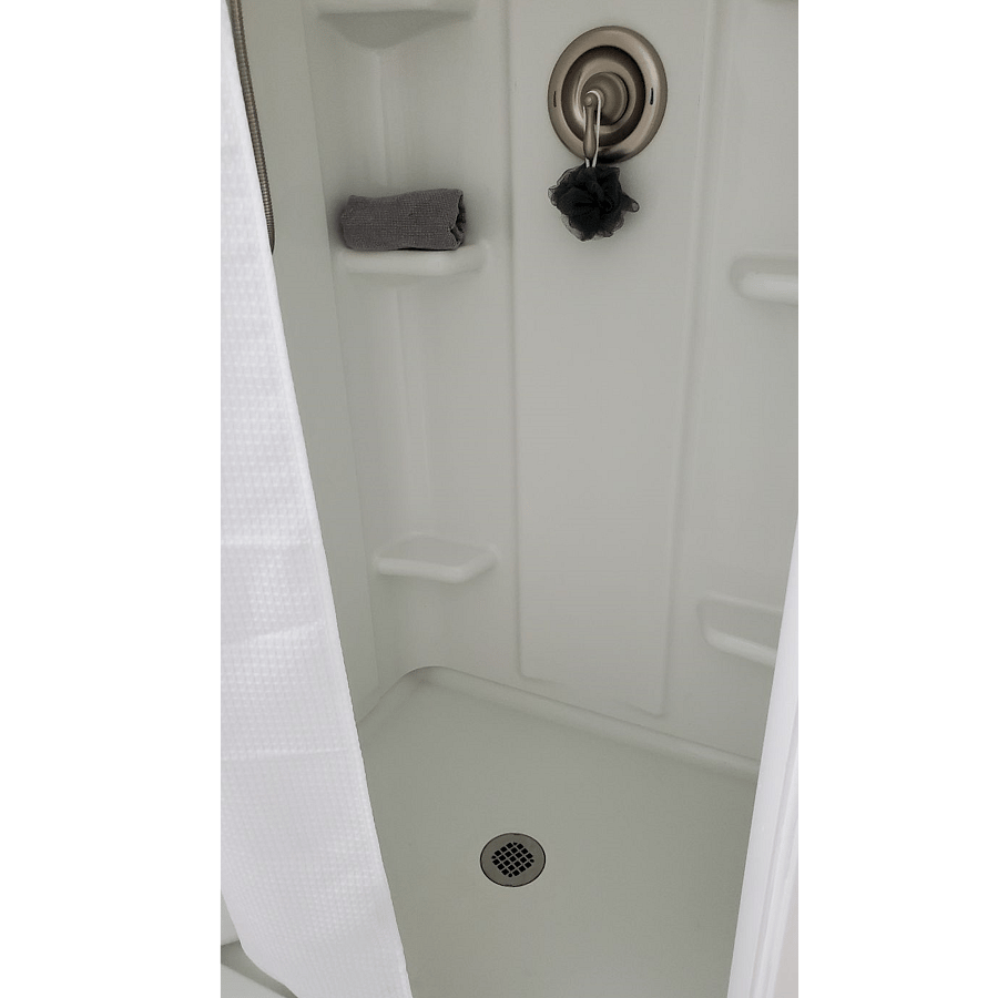 Walk-in shower with curtain.
Modern shower head with multiple settings. Linens & hair dryer in bathroom cabinet.