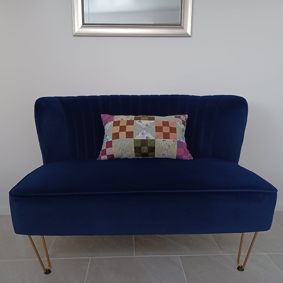 Near the entrance door is a navy blue velvet settee
Tile flooring throughout the studio apt