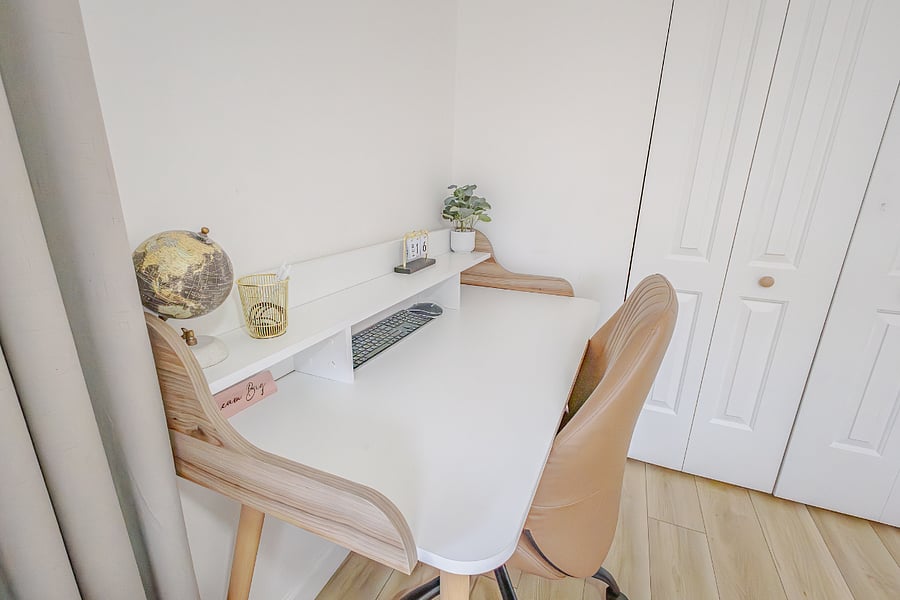 The primary bedroom includes a dedicated workspace with desk and ergonomic chair for remote work or charting.