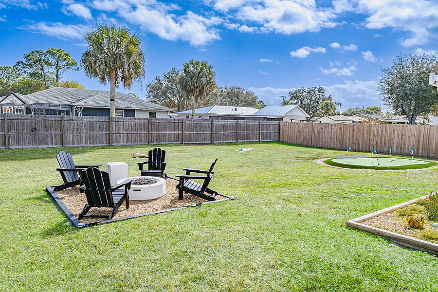 Oversized fenced yard with fire pit, putting green, and room to stretch out under Florida skies.