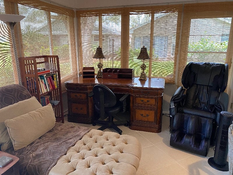 Large wood desk and chaise in office/sunroom