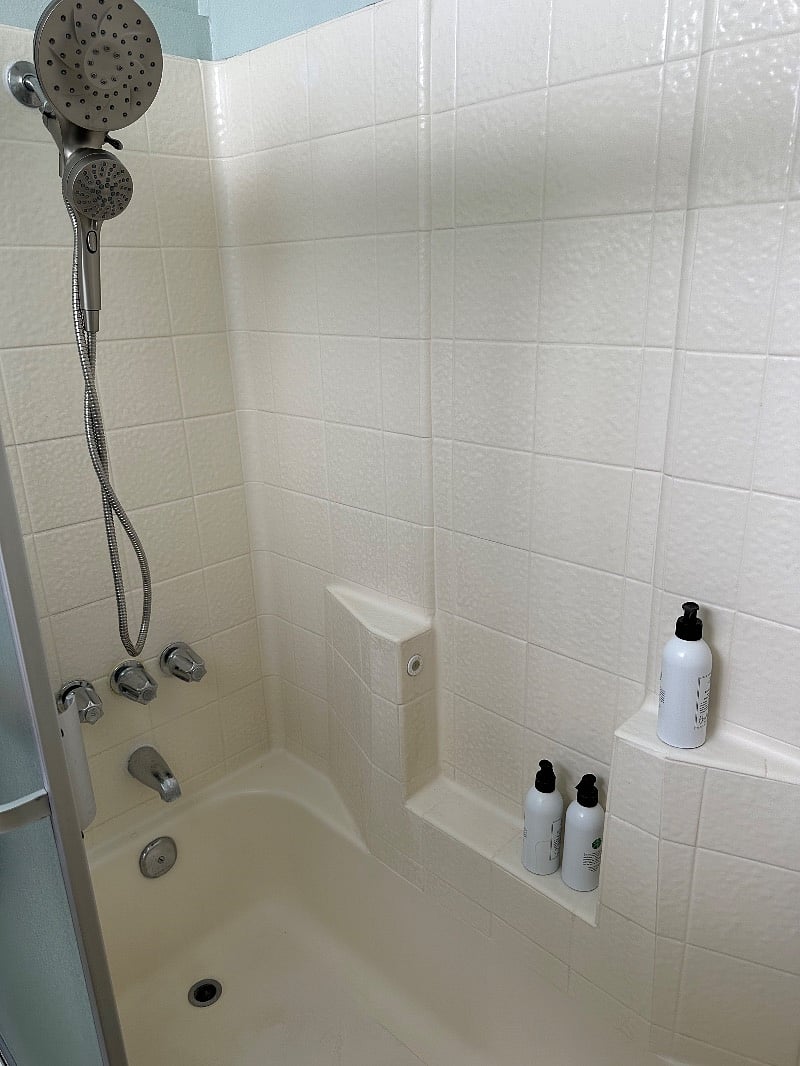 Private tub shower in room with rain shower head