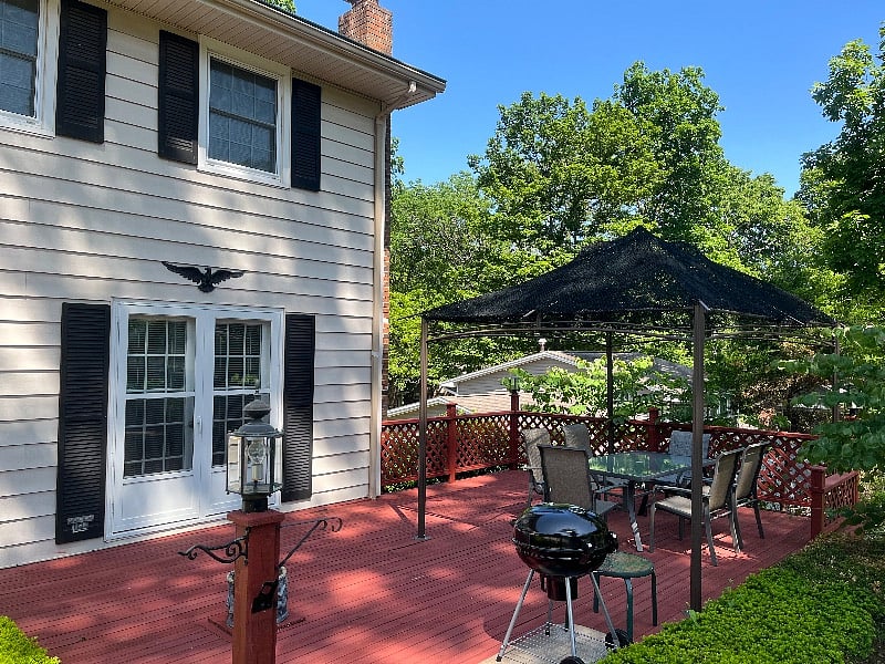 Outdoor patio with dining table for six and charcoal grill. 