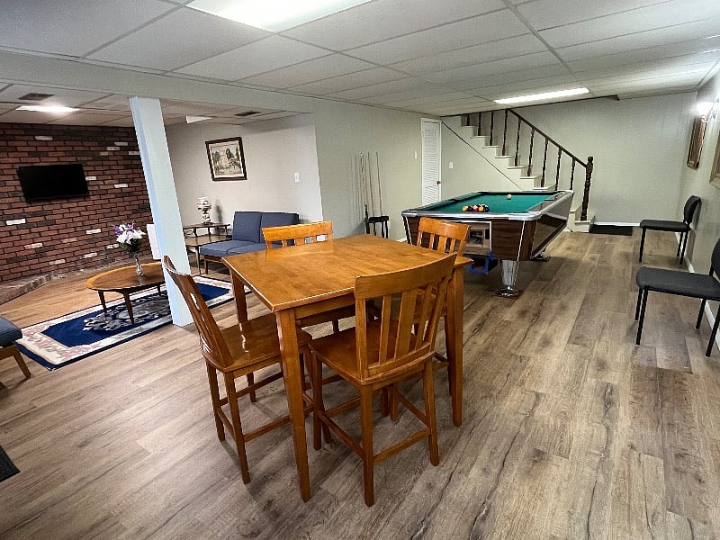 Walkout basement that includes pool table, bar height table, sitting area, and 32" TV with Amazon Firestick.