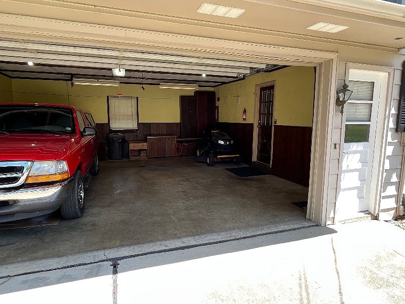 Resident entrance is through rear of house via private drive that serves four houses. A smart lock is located on small door adjacent to large garage door. Property owner stores seldom used vehicle in half of the garage. 