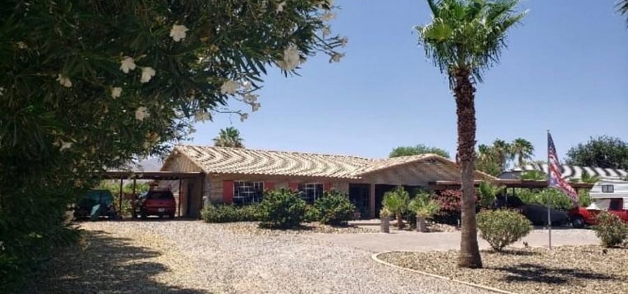 Front of home from street. 4500 sq foot home on 2 acres with total 8 bedrooms, 5 bathrooms and 2 kitchens, divided into a 3 bedroom casita with a private entrance and the 5 bedroom main home with a private entrance. Backyard pool area is shared by entire home and guests! 2 FULL RV HOOKUPS!! 