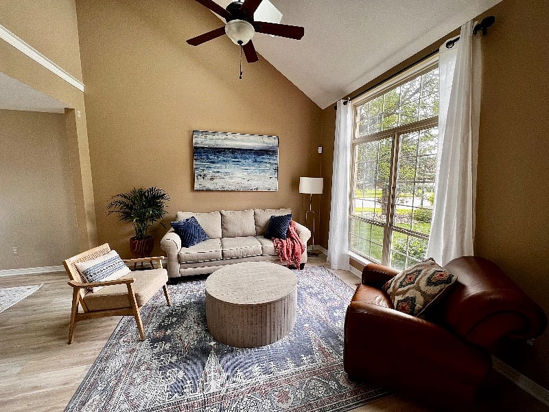 Bight living room with vaulted ceilings flooded with natural light.