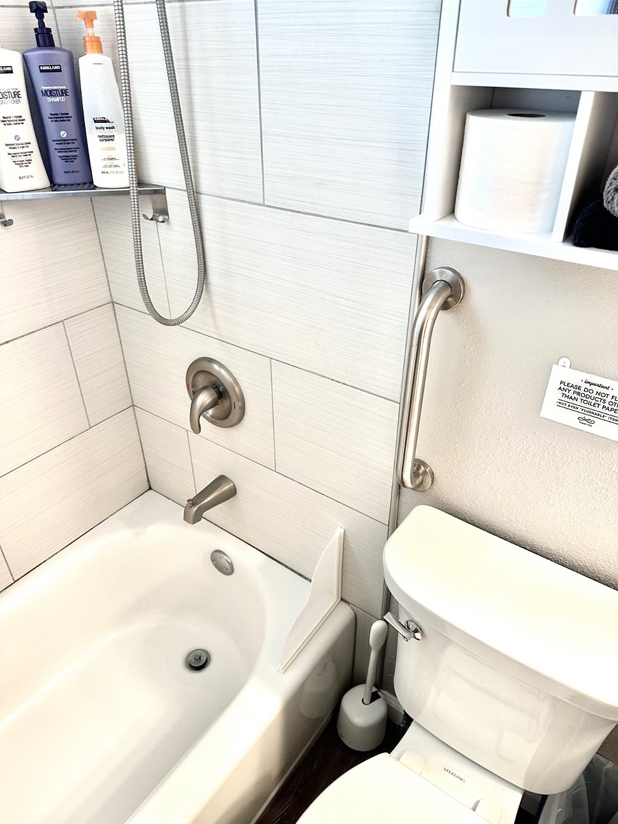 Guest bathroom with tub/shower with safety grab bars. Towels, shampoo, conditioner and body wash included