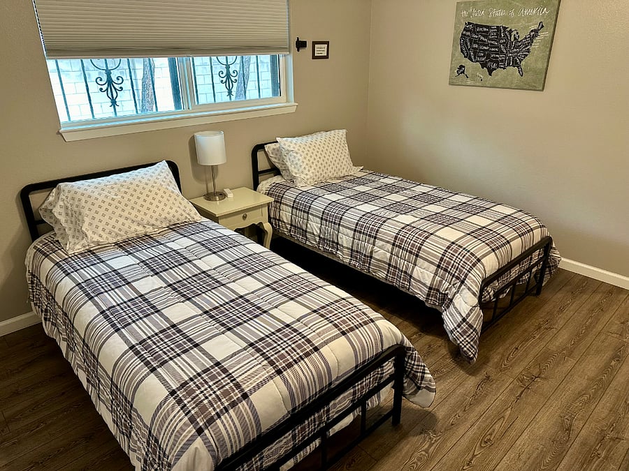 Bedroom #3 with 2 adult twin xl beds, smart tv, dresser and nightstand. High chair and pack-n-play in closet