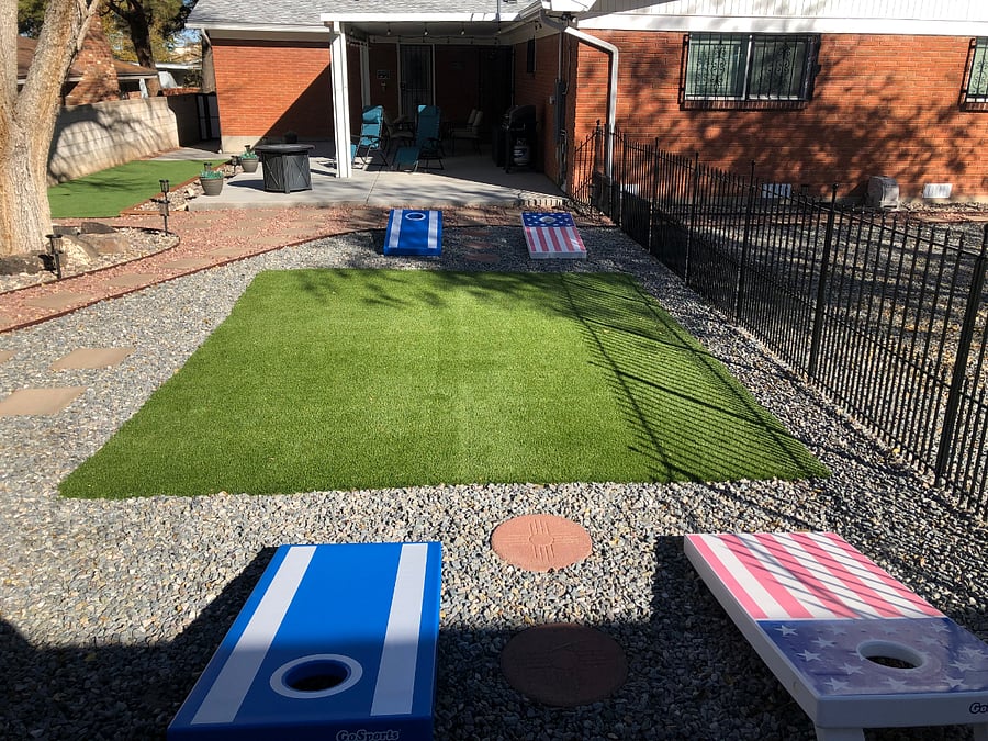 Backyard with grass play area, corn hole games and putting green