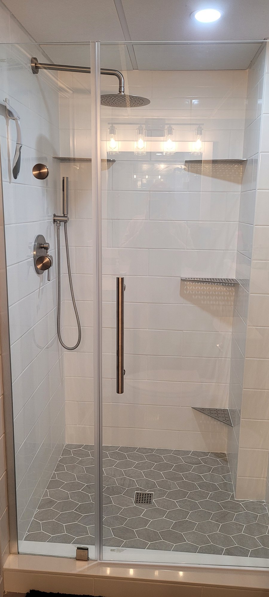 Walk in tiled shower,  with overhead rain shower head. 