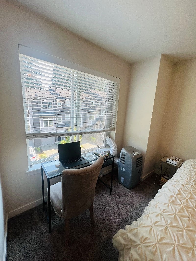 There's a small desk and an AC unit