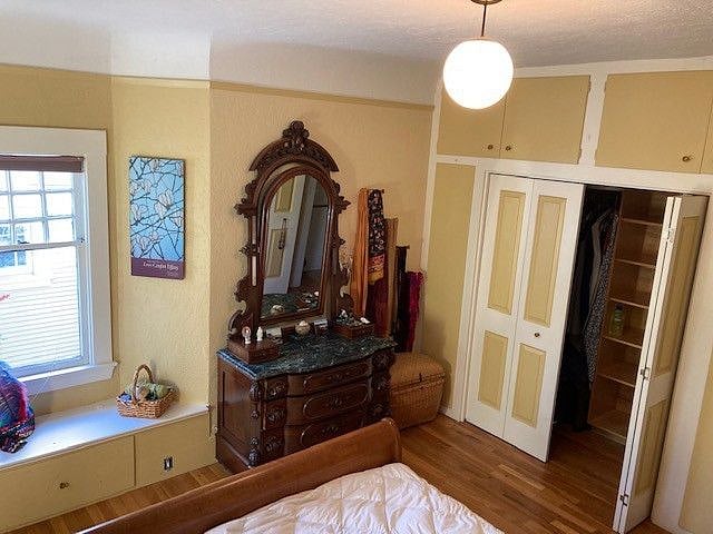 Master bedroom toward bay windows, walk-in closet and antique carved dresser.