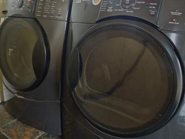 Large LG model front load washer & dryer in large panty lined with large floor to ceiling cabinetry.  Track lighting.