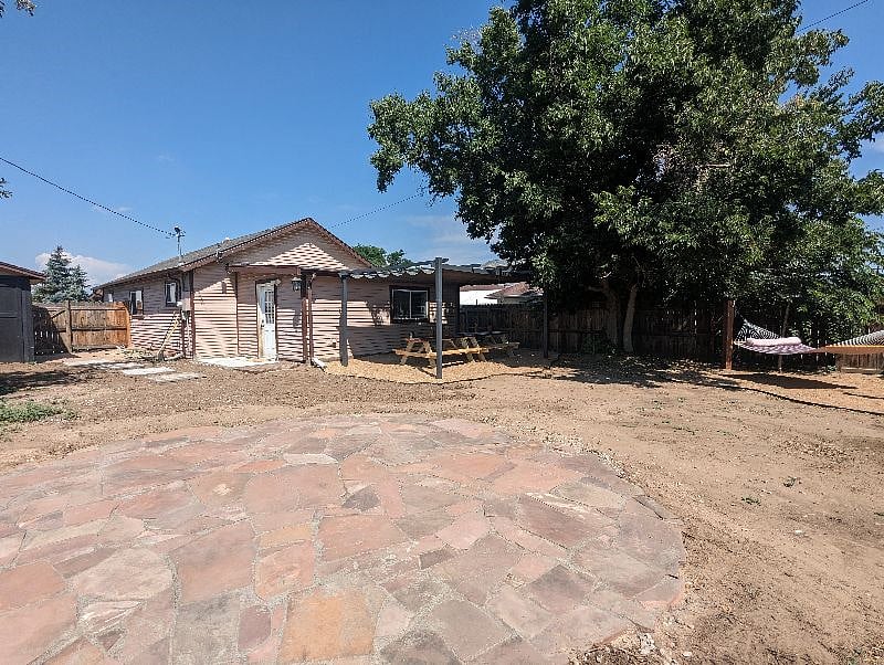 Large recently zeroscaped backyard has a picnic area for dinners, a hammock for lounging and a flagstone patio for yoga with the sunrise.