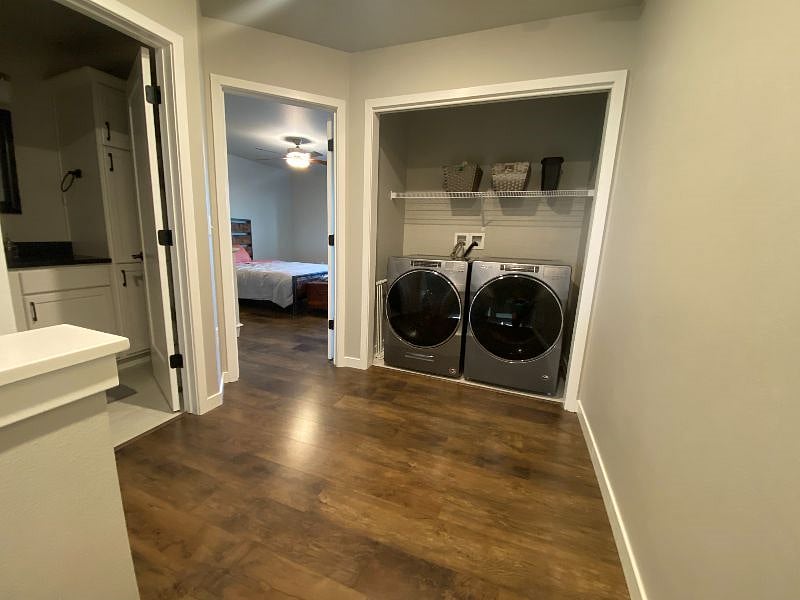 Landing at the top of the stairs with brand-new washer & dryer. View into master bedroom.