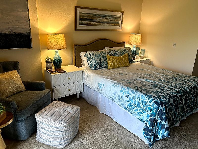 Spacious primary bedroom with large TV, lake view and work station. 