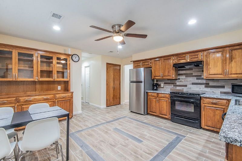 Kitchen equipped with full size fridge, electric cooking range, micro oven and dish washer and a 4 seater dining table and chair.
