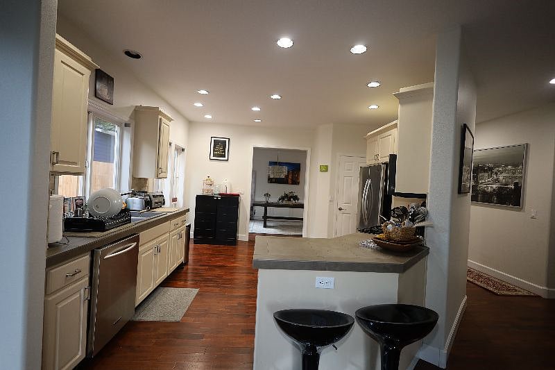 Fully stacked kitchen with Microwave, Gas Stove, Oven, Toaster, Vitamix, Mixer, cutlery, plates, dish washer, sink, dish rack, cleaning supplies, trash can etc.