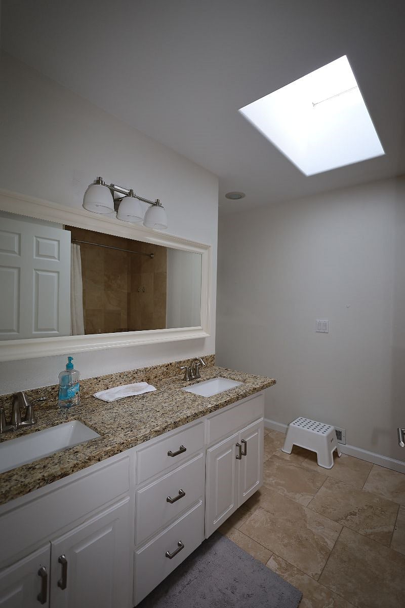 Shared Bathroom - double sink with vanity mirror, toilet and bathroom