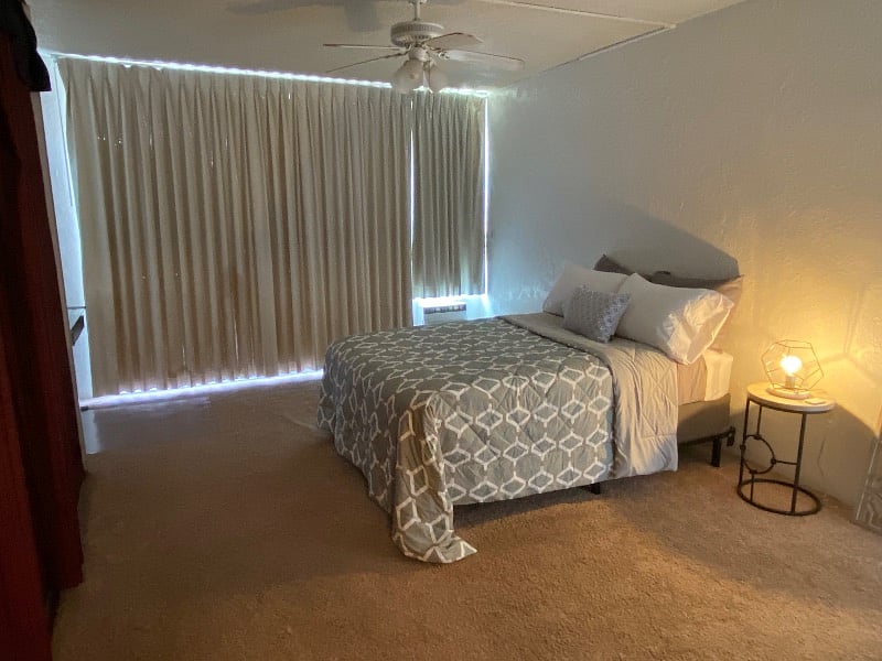 Bedroom with AC and room-darkening curtains.